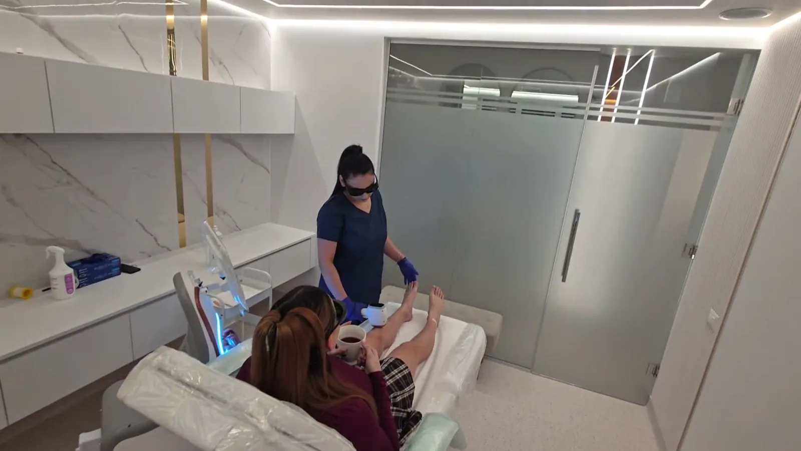 Ședință de epilare definitivă laser în camera de tratament Contur Center — tehniciana lucrează, clienta stă relaxată