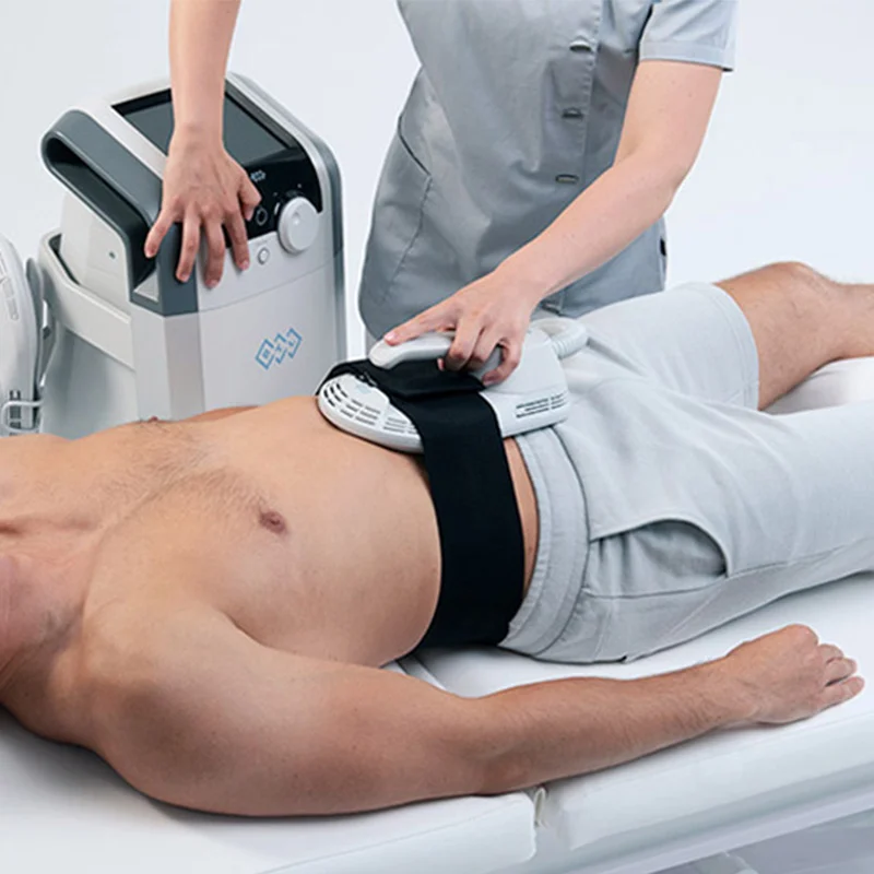 Aplicatorul BTL EMBODY prins cu o centură pe abdomen, în timpul unei ședințe de tonifiere musculară